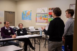 Pope John Paul II High School students giving a presentation for a couple adults