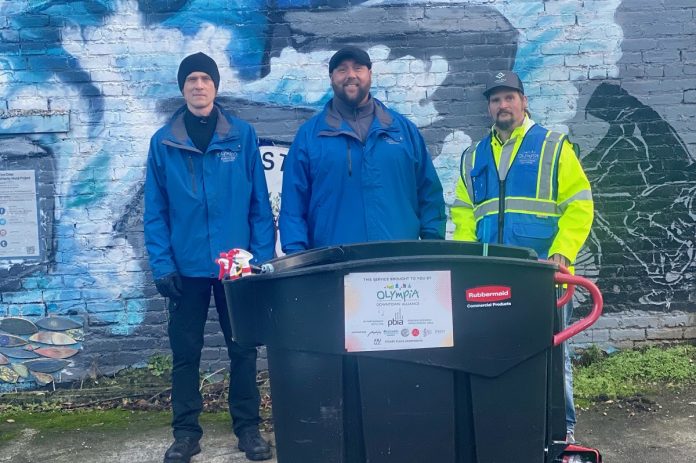 From left: Matthew Knox, Olympia Downtown Alliance's Maintenance employee, Kyle Nicholas, Alliance Operations Manager and Josh Burrage, Valeo intern. standing by a large garbage bin