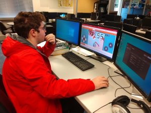 Tumwater High School student Andrew Chappel works across multiple screens as he creates games in his video game programming class.