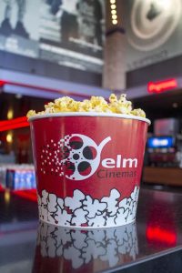 yelm cinemas red popcon bucket with popcorn inside sitting on a counter