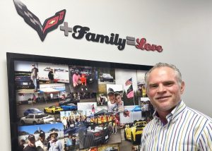 Dr. Duncan of Duncan Integrative Medicine standing in front of a board full of car photos