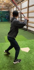 kid about to swing at a baseball with a bat