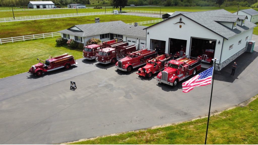 aerial shot of firehouse 5 with vintage 7 fire trucks parked outside