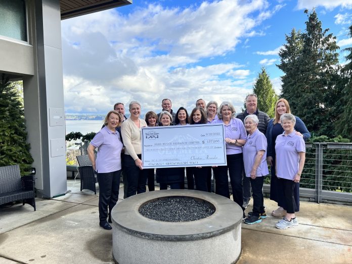 a group of men and women holding a large check outside Olympia Country and Golf Club