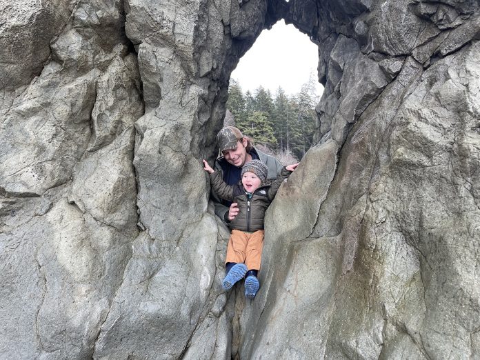 Father and son climbing on rocks at Ruby Beach