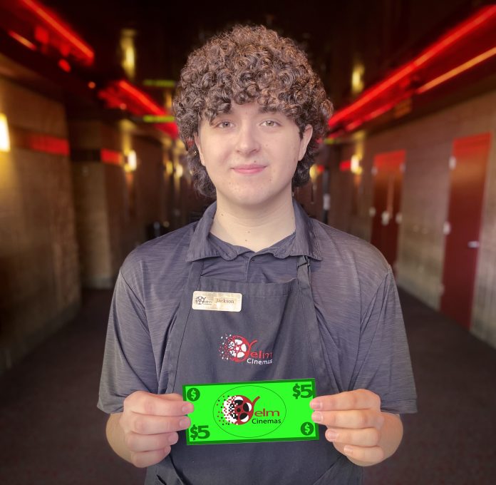 Yelm Cinemas worker holding a fake $5 bill