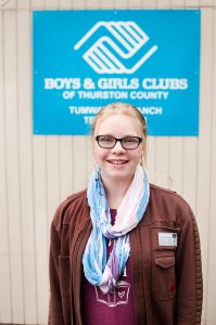  Lilly Wilson,  Boys & Girls Clubs of Thurston County 2023 Youth of the Year standing in front of the Boys & Girls Club logo