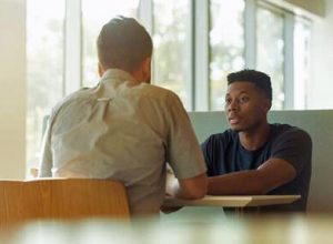 two men sitting in a restaurant talking