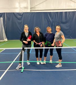 four woman standing on a pickleball court at Steamboat Tennis and Athletic Club