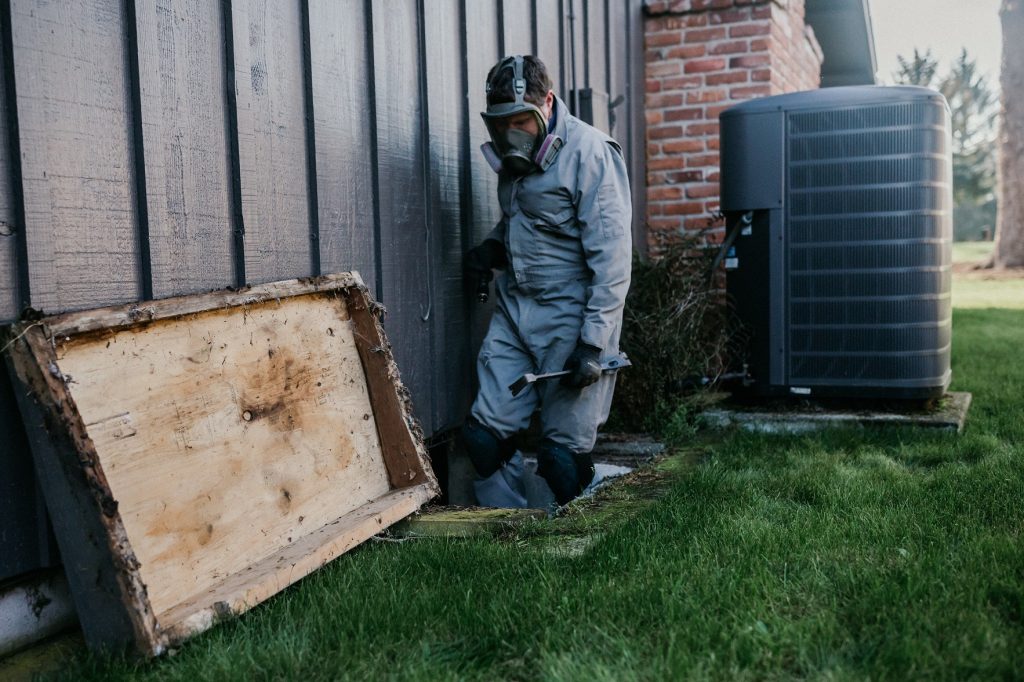 Boggs Inspection Services Tech going into a crawl space under a house