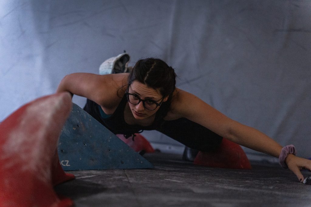 a photo of a person climbing a rock wall, taken from above.