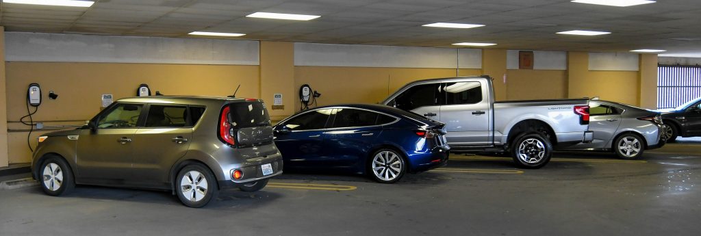 electric cars in a covered parking garage at charging stations