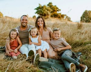 Krissie, her husband and their three children in a field