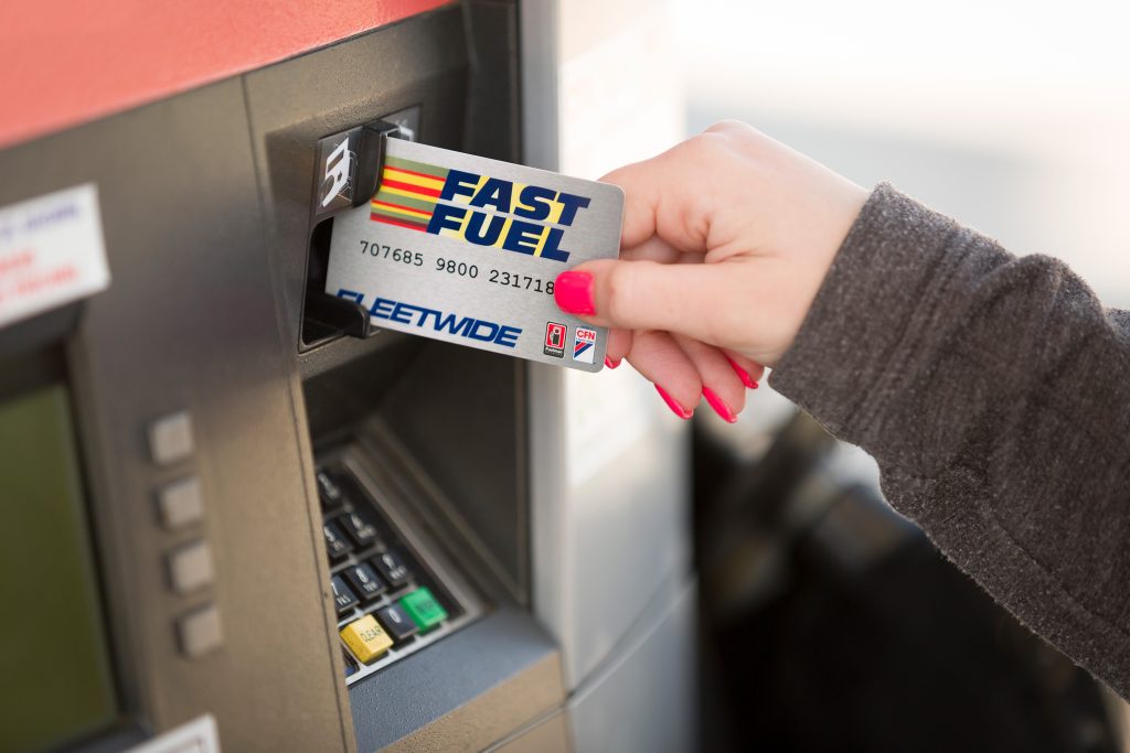 A person inserting a Fast Fuel member card into the pump