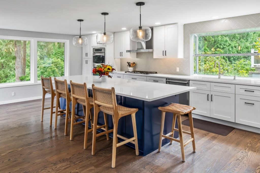 A kitchen table with an island with chair stools at it