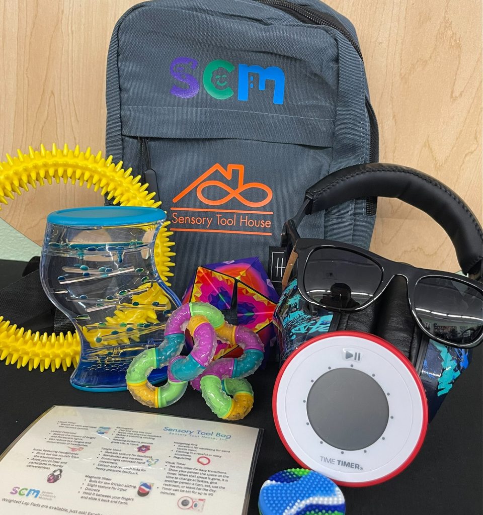 backpack with an assortment of sensory toys in front of it and a handout from Sensory Tool House