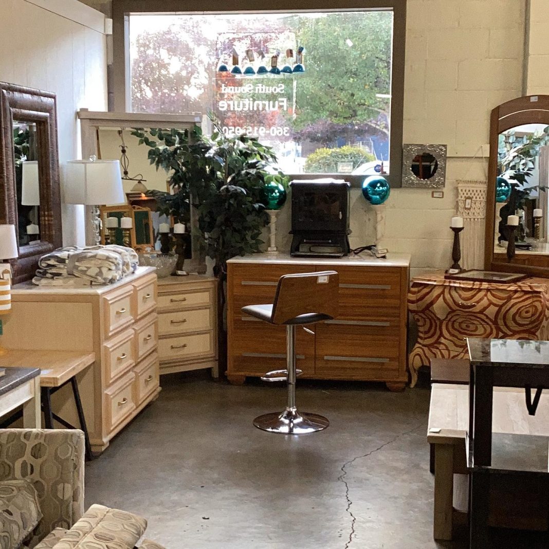 several wood dressers with mirrors and plants on them at South Sound Furniture in Olympia