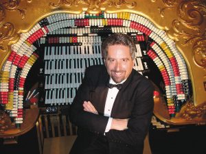 The Washington Center's house organist Dennis James standing in front of the organ