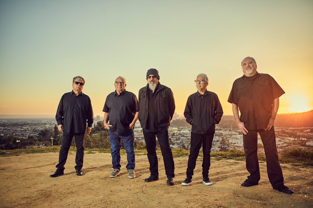 Los Lobos band standing in the desert at sunset