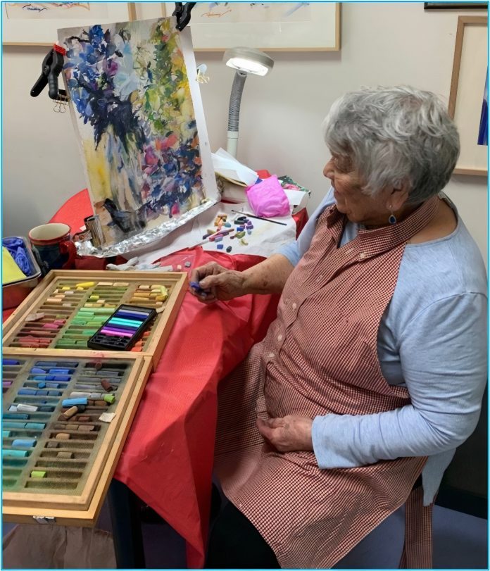 Local painter Jane King working at a desk.