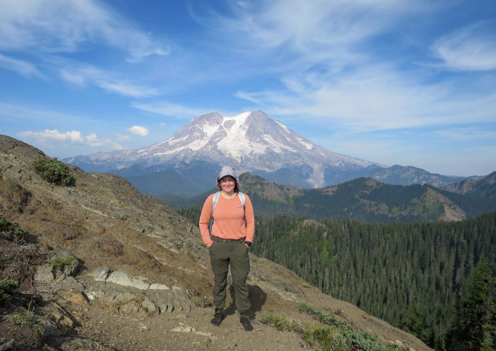 Vivian Blanco standing on an edge with a mountain in the background