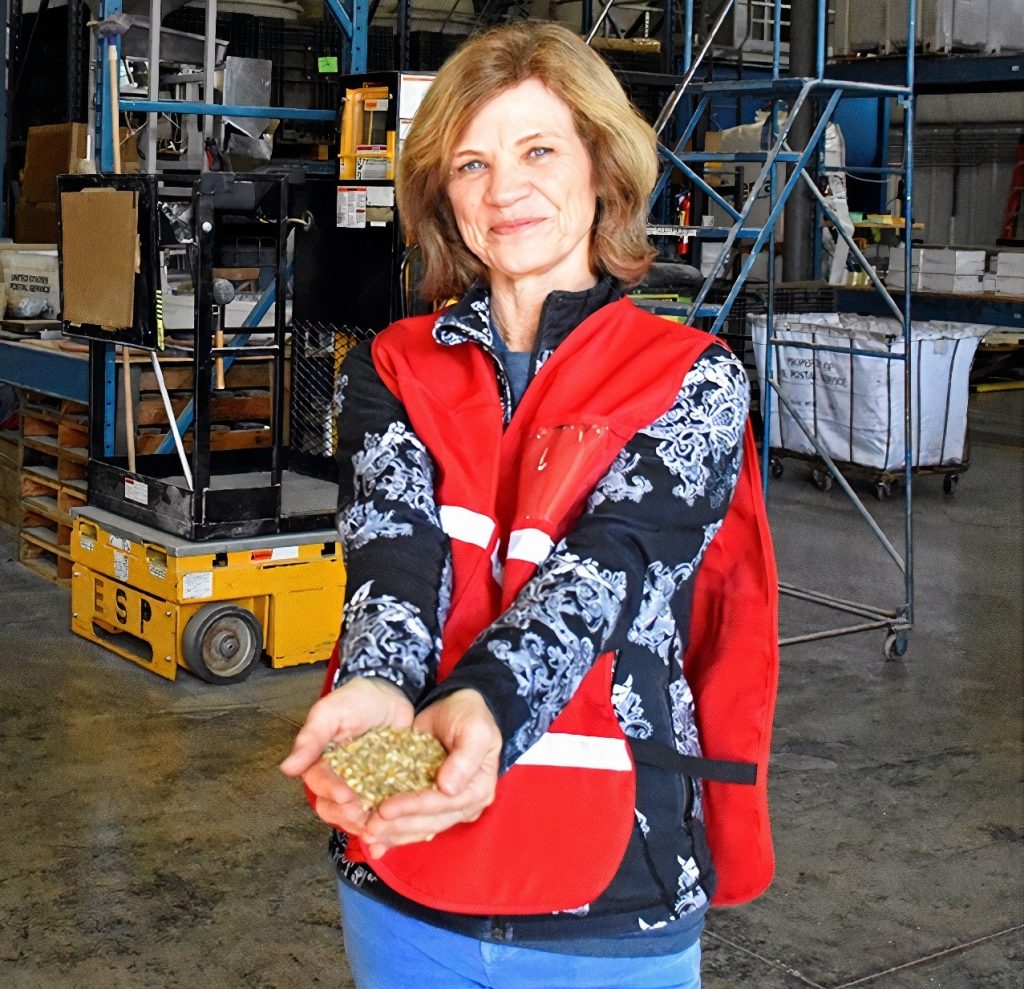 Scratch and Peck Founder Diana Ambauen-Meade holding a handful of seed in her outstretched hands