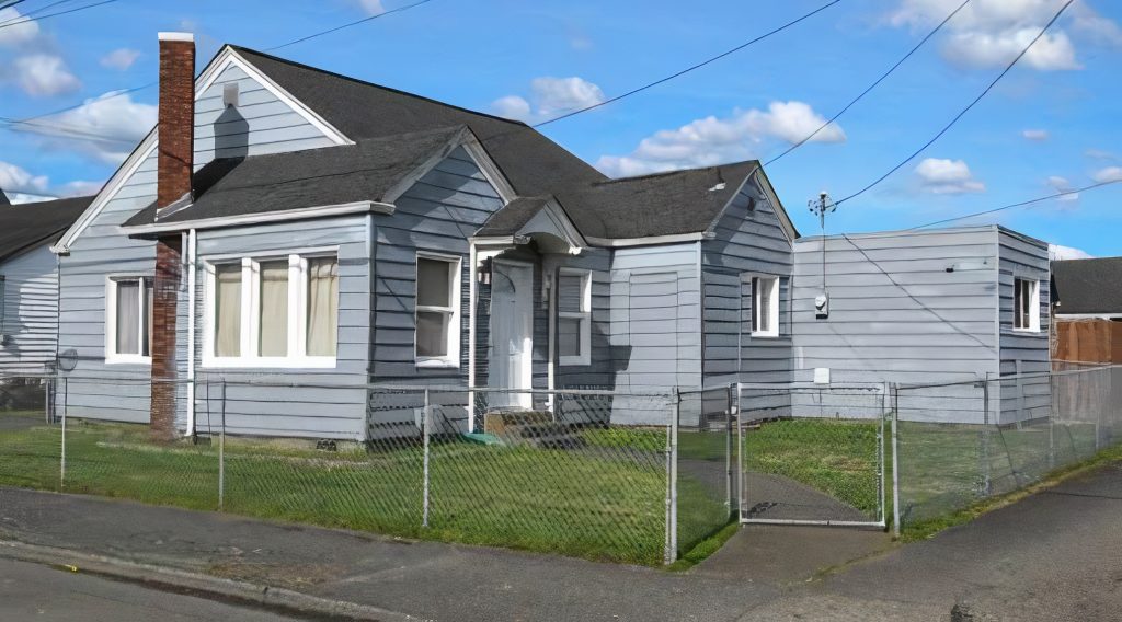 grey one story house with a chain link fence