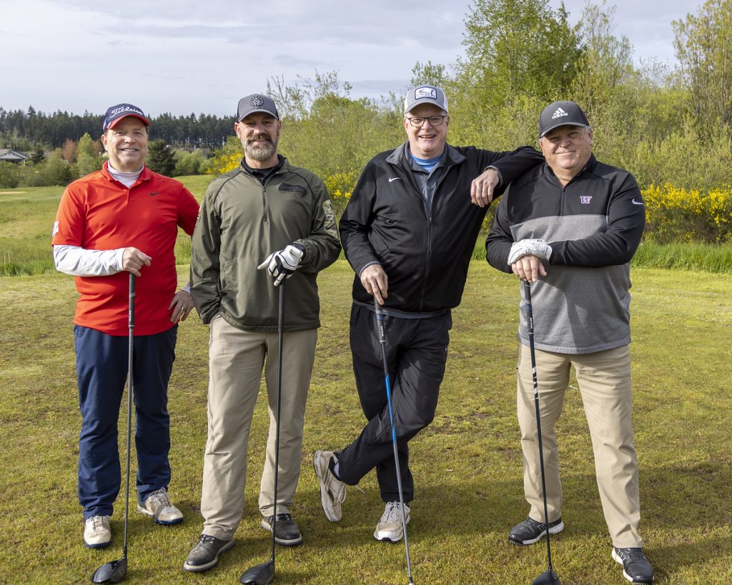 four golfers standing on the green