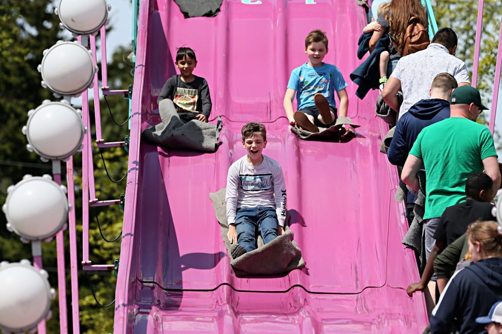 people going down a giant pink super slide