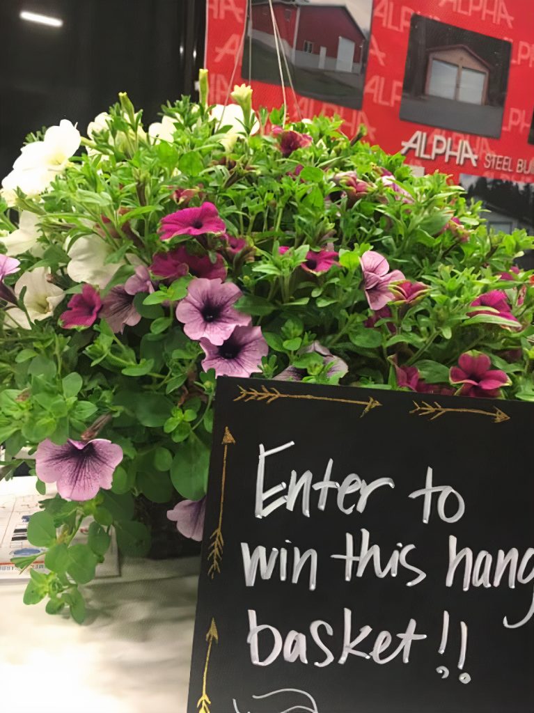 a close up of a petunia hanging basket with a sign that says, 'Enter to Win this basket.'