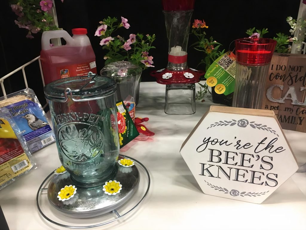 A table with glass hummingbird feeders on it