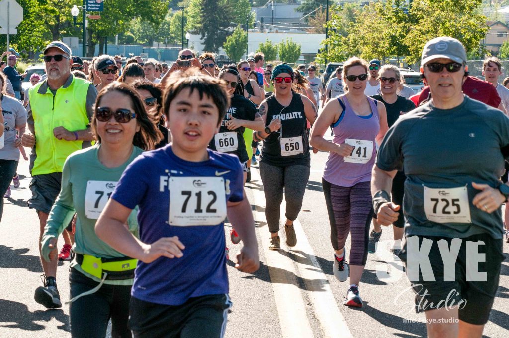 Large group of runners with numbers on their chests.