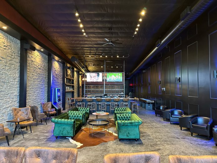 green velvet couches, leather chairs at tables, a bar, two big screen tvs and a cowhide inside 1779 Tenino Bar