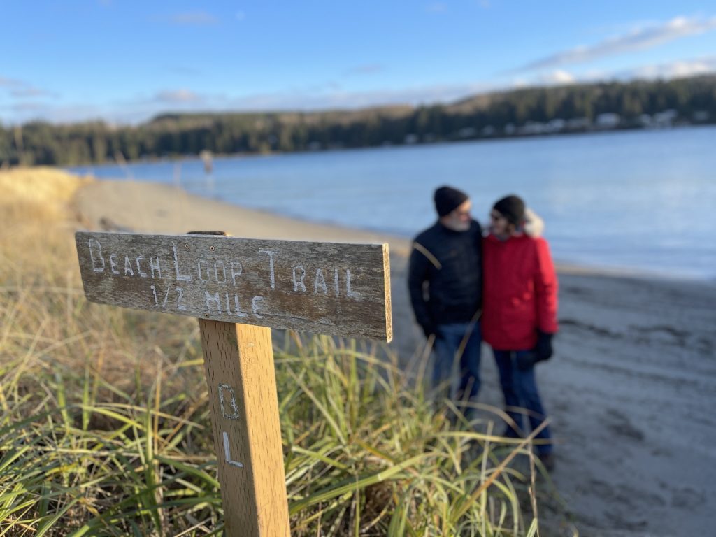 couple looking at each other while standing on a beach