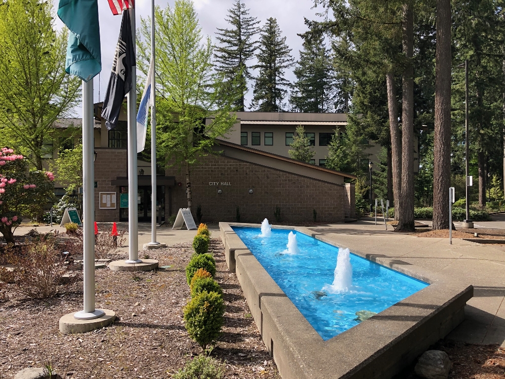 Lacey City Hall with flags and a water feature with three fountains