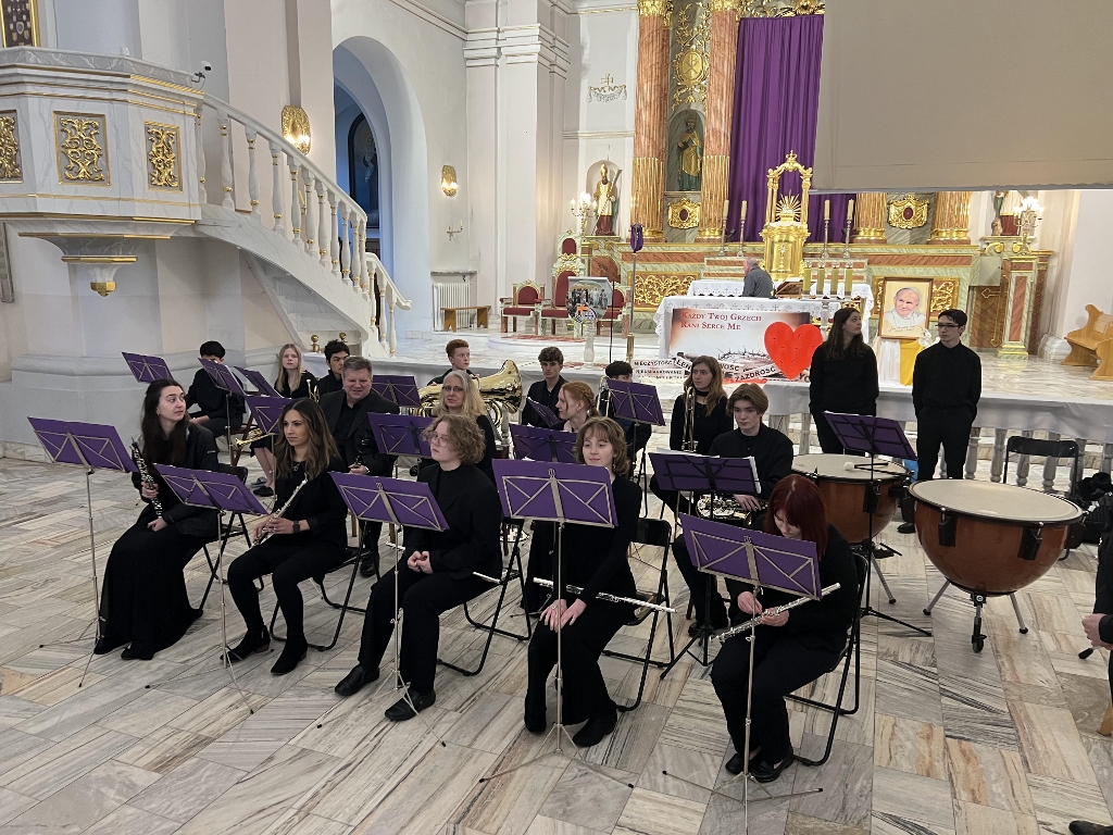 North Thurston High School band students in a ornate building seated with their instruments