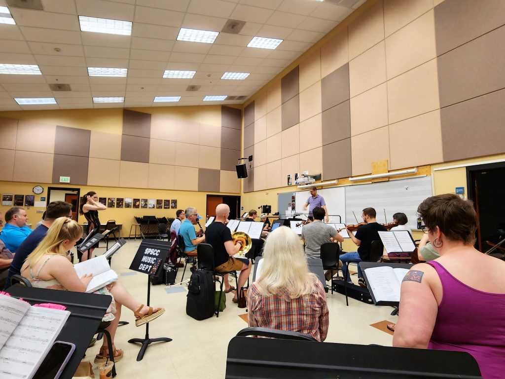 an orchestra practices in a large room