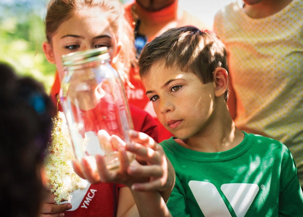 kids looking at a clear glass jar