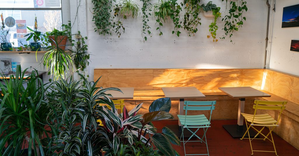 Tables and chairs surrounded by plants at Stellar Juices in Olympia