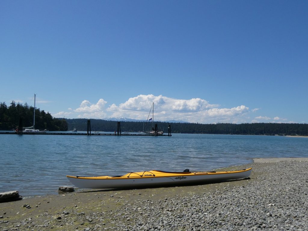 yellow kayak on a rocky beach with ocean in the background