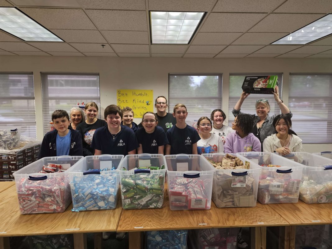 Komachin Middle School Future Business Leaders of America standing behind a long table with food in bins
