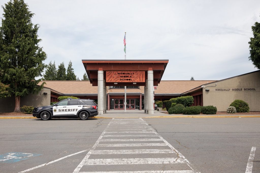 a police car sitting outside a school building enterance