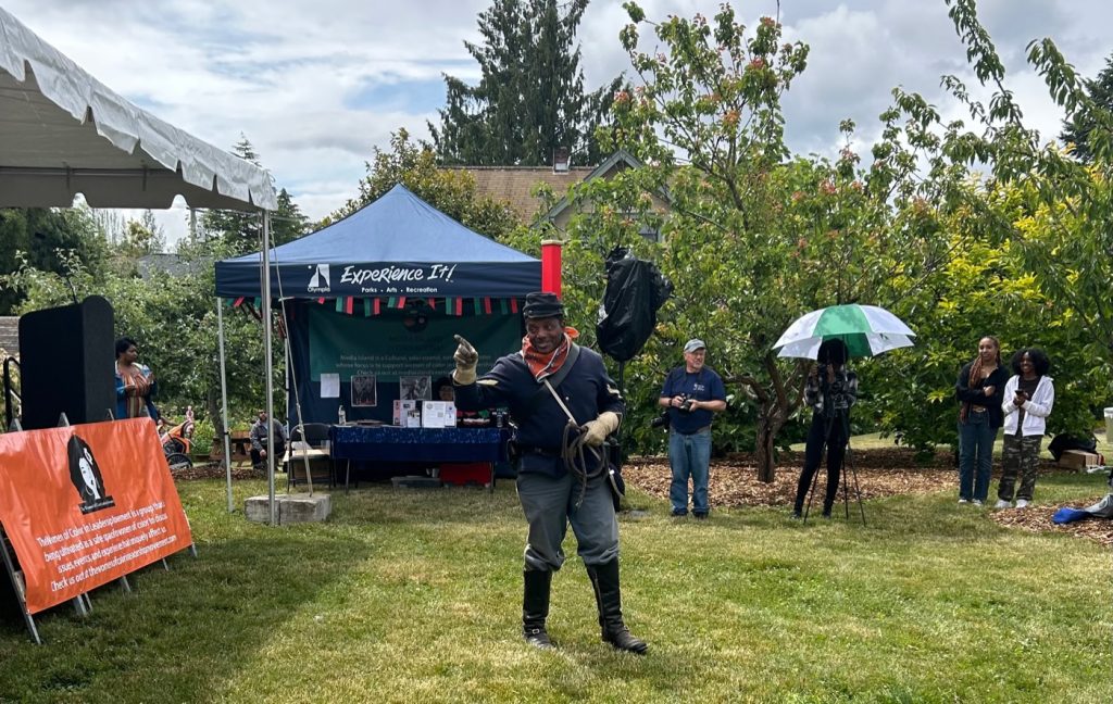 Buffalo soldier standing in grass outside a blue pop up tent