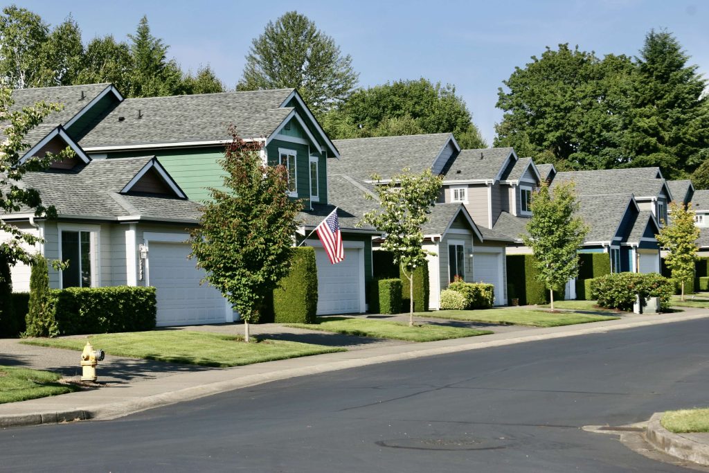 rose of houses with trees, front lawns and a sidewalk