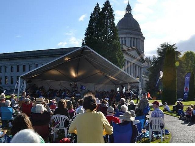Party Event Rental Celebrations-Olympia-symphony-band-shell large group of people sitting facing a bandshell stage with an orchestra playing