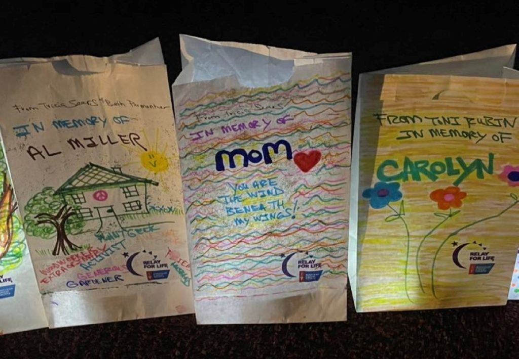 three Luminaria decorated with color drawings and lots of writing