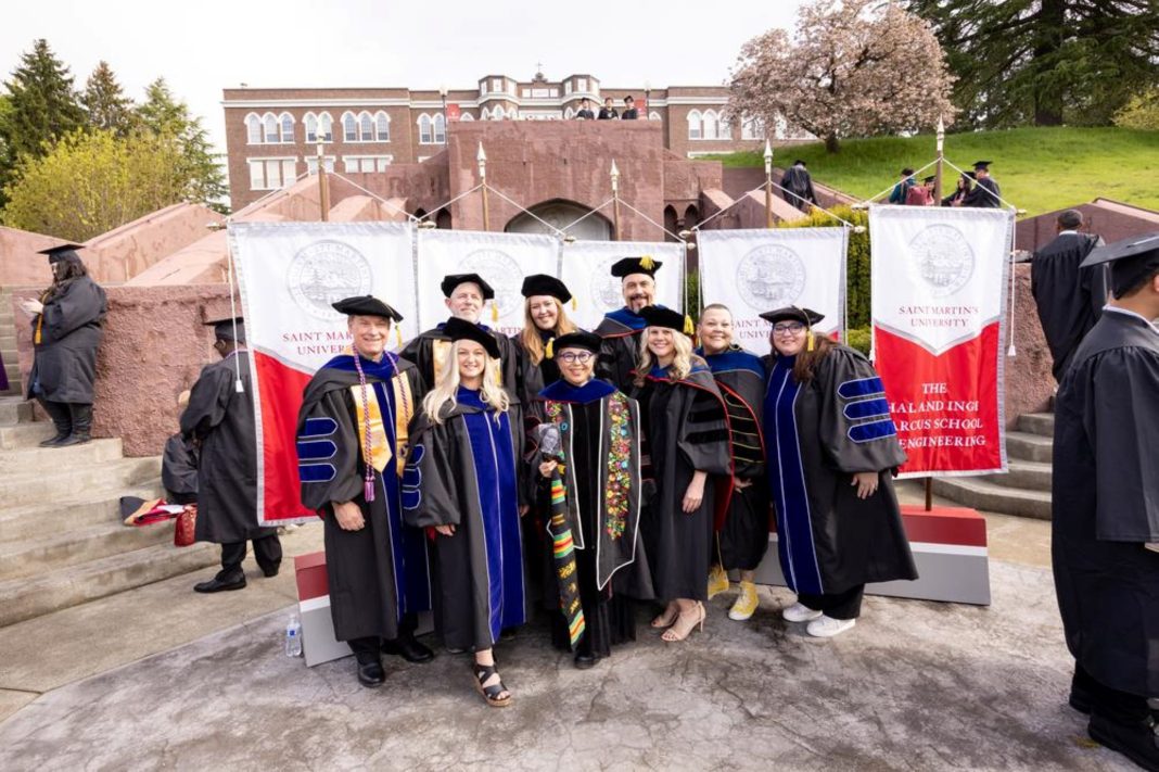 Nine new Ph.D. graduates from Saint Martin's University standing outside at Saint Martin's University