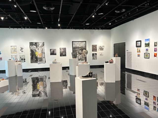 the inside of the gallery displaying ceramic pieces, drawings, paintings, prints, photographs, and more.