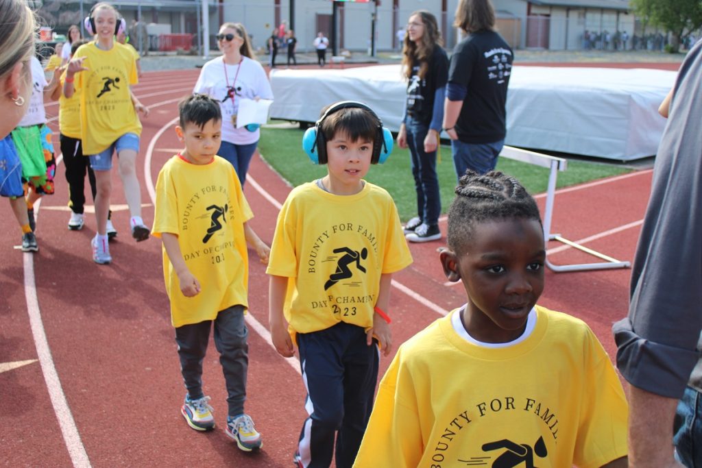 students in yellow walking along the track