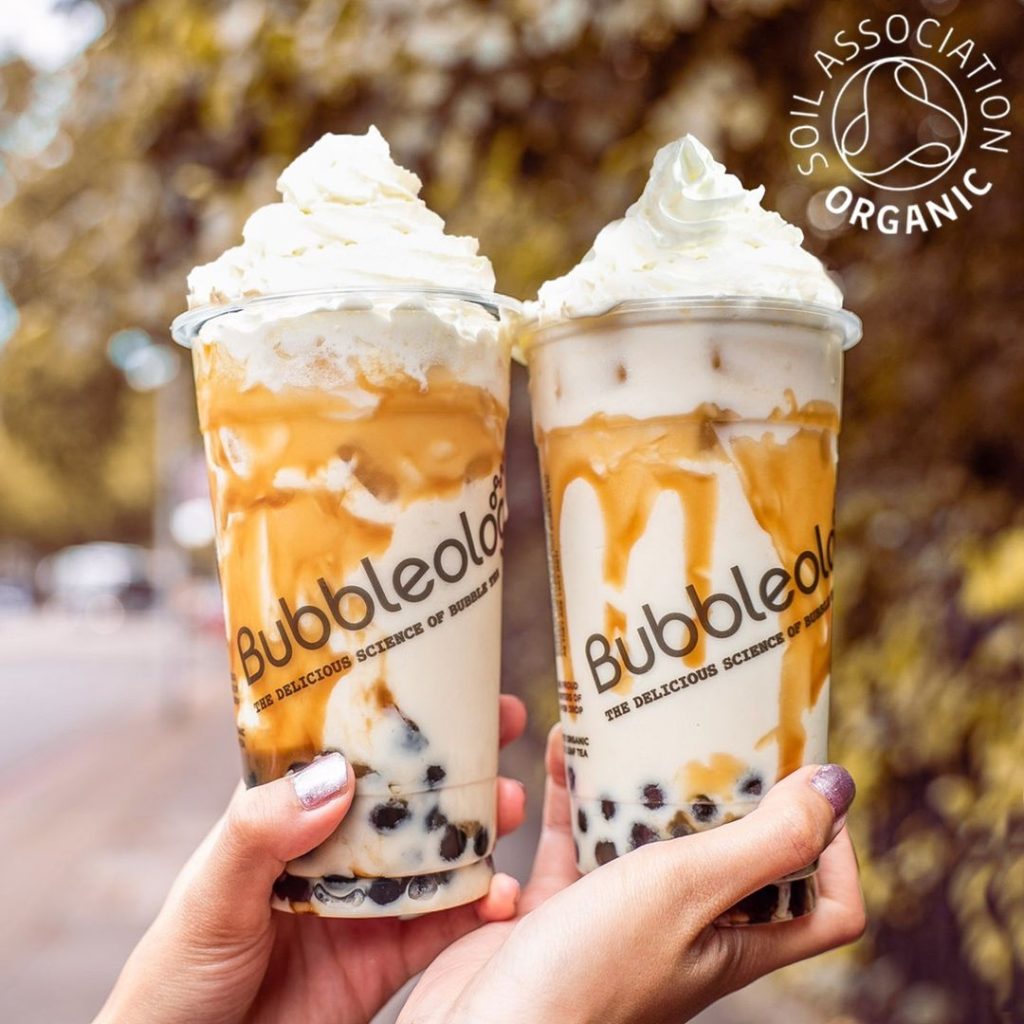 two milk tea drinks with boba, whipped cream and carmel drizzle